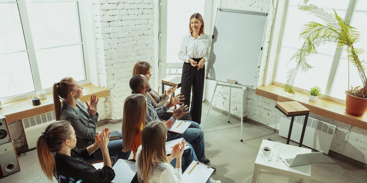 Female speaker giving presentation in hall at workshop