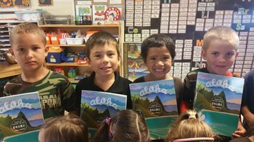 four boys holding aloha books