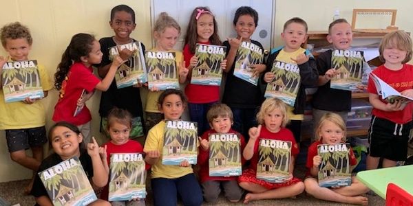 a group of kids showing their aloha books