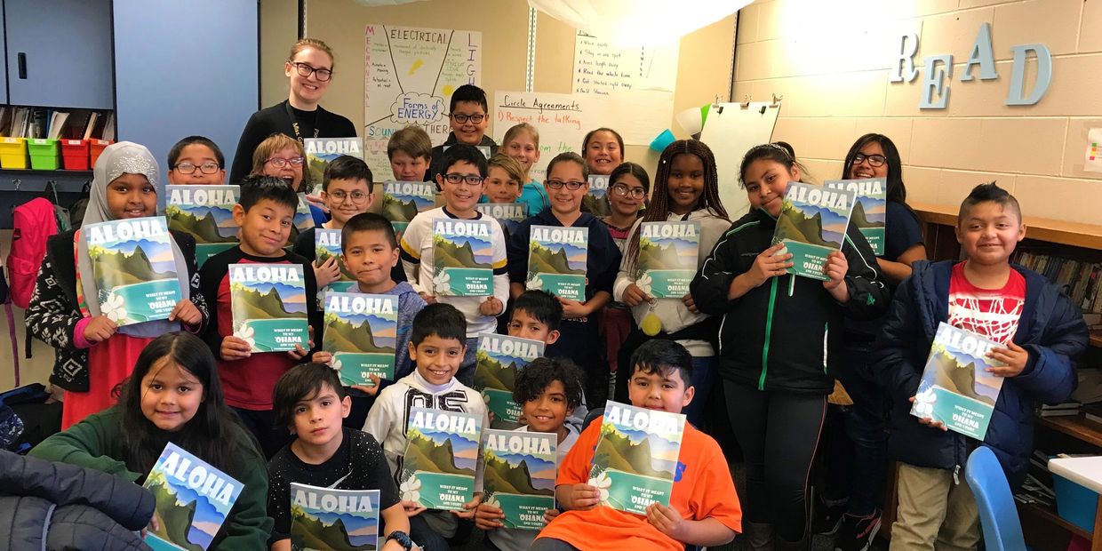 a group of kids holding Aloha books