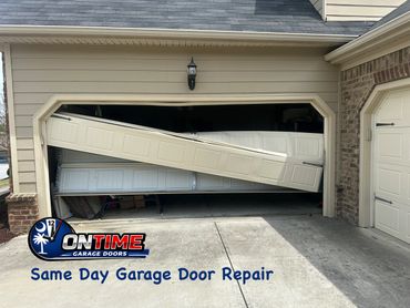 Damaged garage door bent and off track, with repair service advertisement.