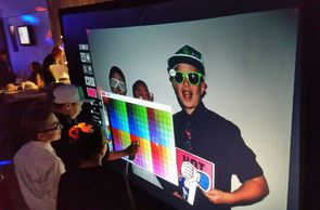 Screen projects a virtual wall for guests to use interactive pens to decorate their photo. 