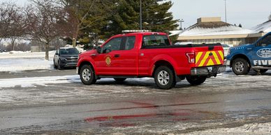 Red emergency pickup truck parked on icy road.