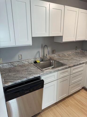 Modern kitchen with white cabinets, granite countertop, stainless steel sink, and dishwasher. Kitchen remodeling services and home renovations done by Durango Renovations.