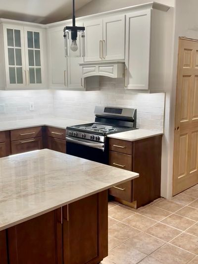 Modern kitchen with white upper cabinets and brown lower cabinets. Kitchen remodeling services and home renovations done by Durango Renovations