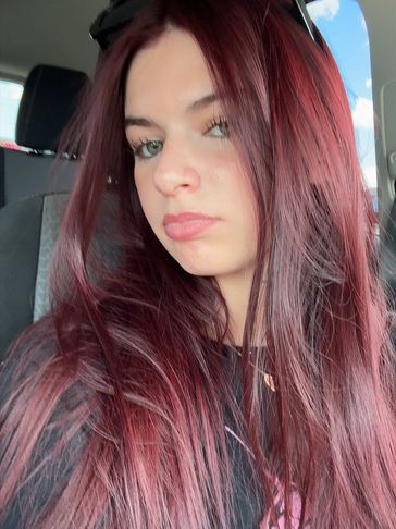 Woman with long reddish hair in a car.