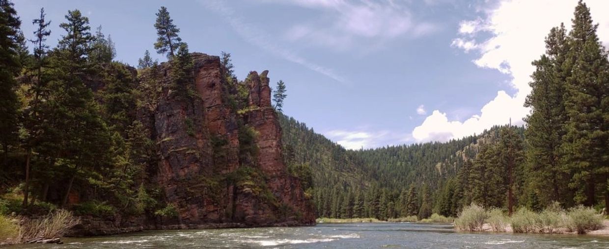 Red Rock cliffs on the left with the Blackfoot River while using Fly Fishing Guides in Montana 