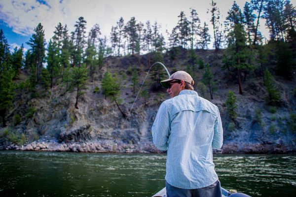 Client with a bent rod while using Clark Fork River Fishing Guides