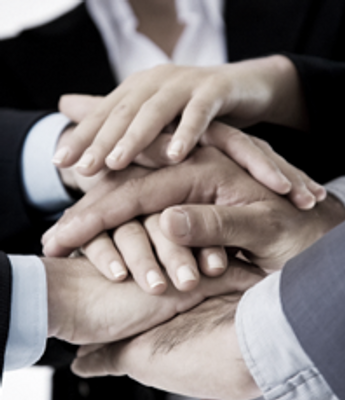 A stack of hands belonging to a diverse business team