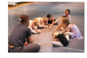 Teacher talking to a creative moment ballet class gathered in a circle
