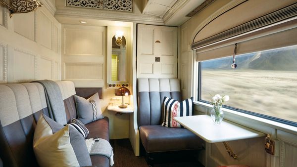Interior de una cabina de lujo en el tren Andean Explorer con vista a paisajes peruanos.