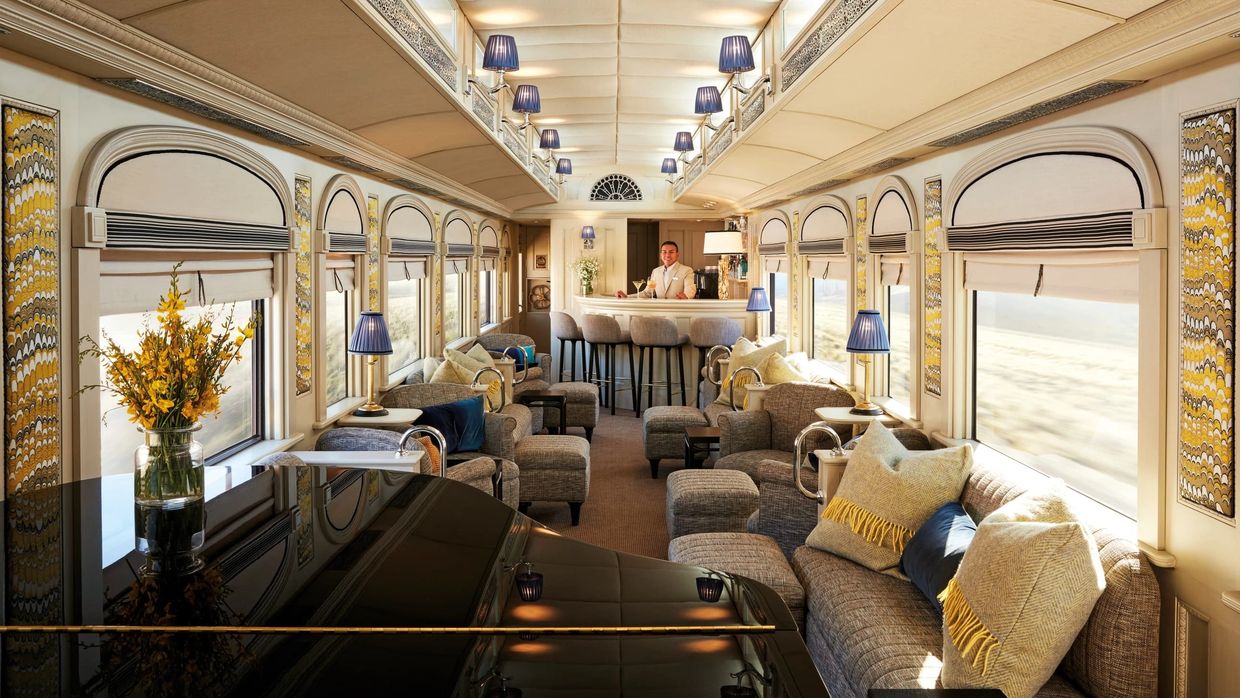Elegante coche bar del tren Andean Explorer con piano, cómodos sillones y servicio de barman.