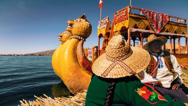 Habitantes de los Uros en balsa tradicional de totora sobre el Lago Titicaca, Perú.
