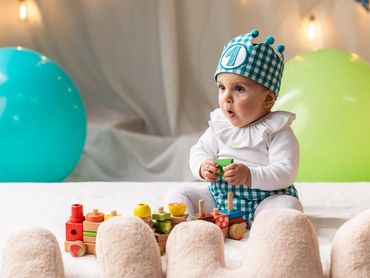 niño 1 año en estudio sentado con tarta