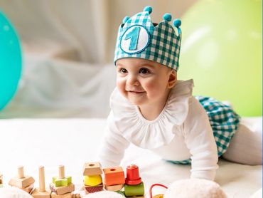niño 1 año en estudio sentado con tarta