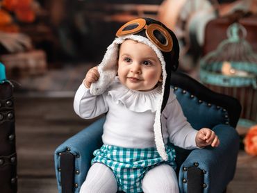 niño 1 año en estudio sentado con casco de aviador