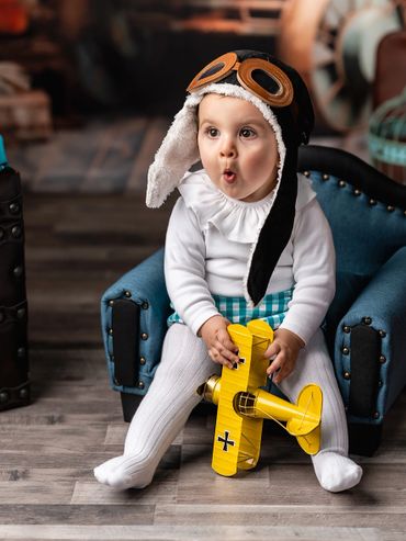 niño 1 año en estudio sentado con casco de aviador