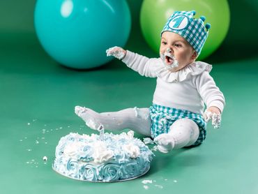 niño 1 año en estudio sentado con tarta