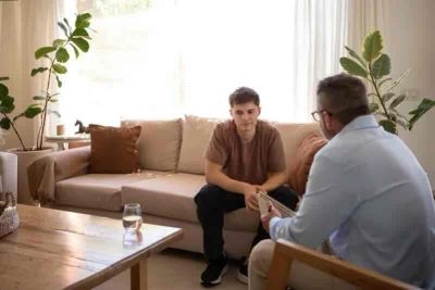 Teenager speaking with a therapist during an individual counseling session in a calm therapy office