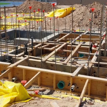 Early stage of a building foundation with wooden formwork and rebar.