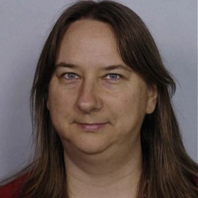 Portrait of a woman with long brown hair and a neutral expression.