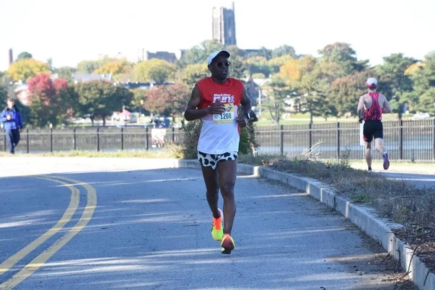 Runner in bright shoes and patterned shorts on a sunny race day.