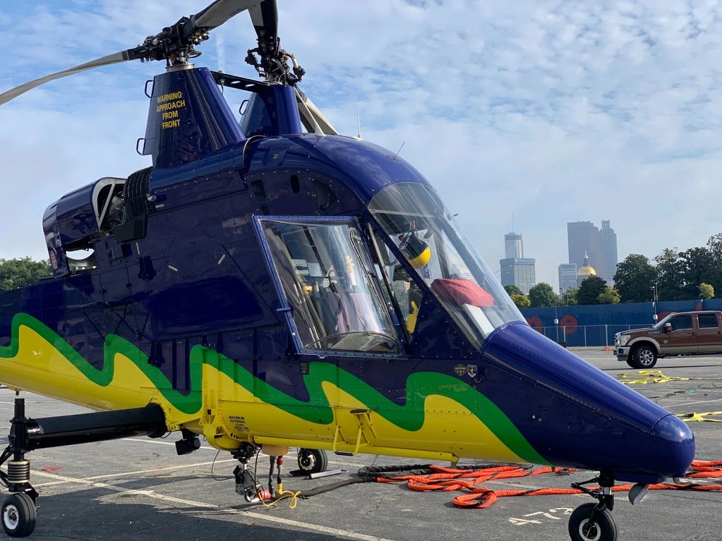 Colorful helicopter with cityscape background.