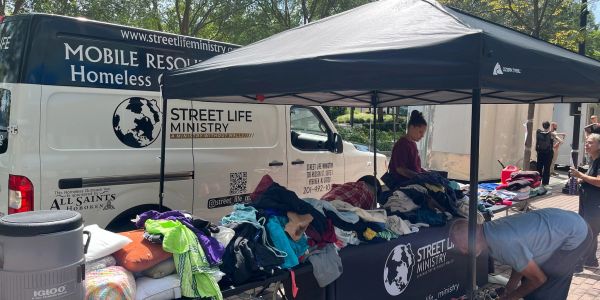 Street Life Ministry offers clothing to homeless people outdoors.