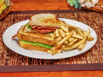 Bacon sandwich with lettuce and French fries.