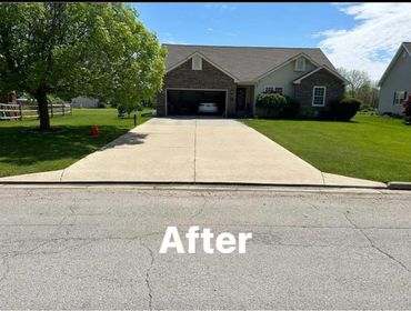 Clean and smooth concrete driveway in front of a suburban house with green lawns.