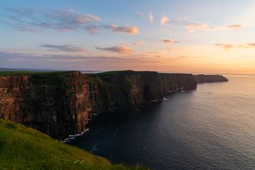 Sunset over rugged coastal cliffs.