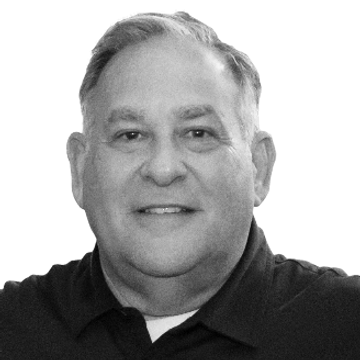 Smiling man in a black polo shirt.