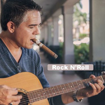 David Remland smoking a cigar and playing guitar.