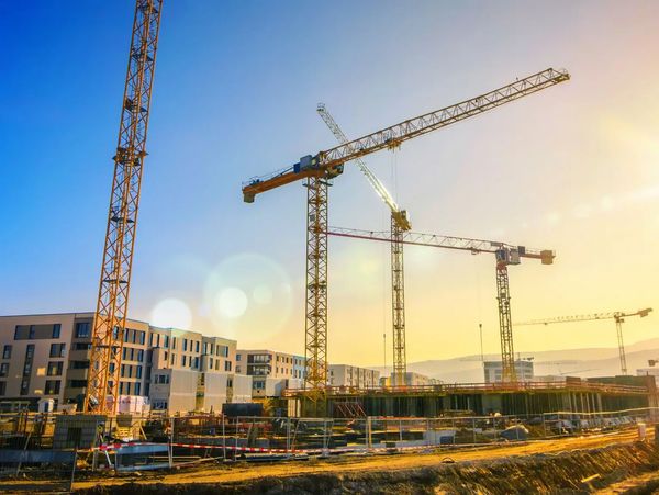 Construction cranes at sunset