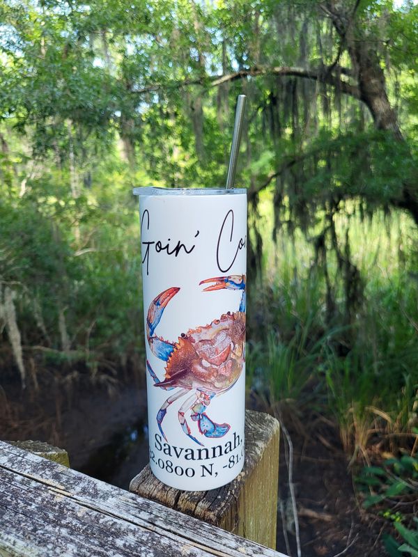 Travel tumbler with crab image and custom location and GPS coordinates on a bridge post by the marsh