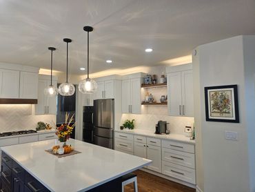 Modern kitchen with white cabinetry, a large island, and pendant lighting.
