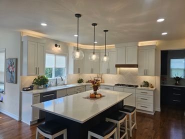 Modern kitchen with white cabinets, large island, and pendant lights.