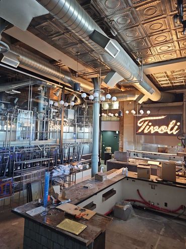 Industrial-style bar under construction with Tivoli sign.