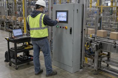 Controls engineer commissioning a consumer packaged goods conveyor from an industrial HMI.