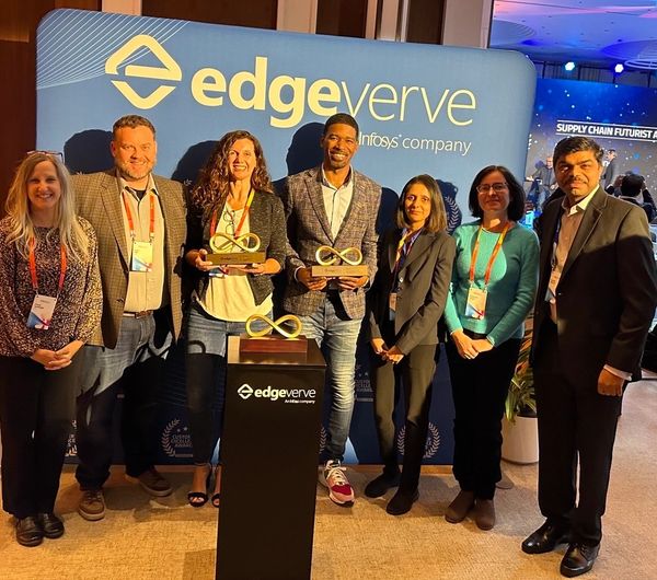 Seven professionals pose with awards at an EdgeVerve event.
