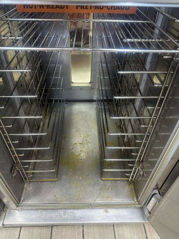 Empty metal oven rack with some grease stains inside.