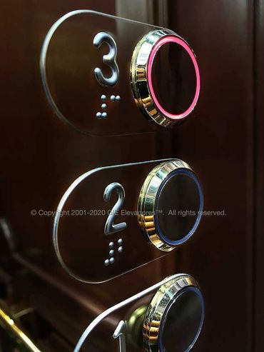 Detalle de botones de un elevador de madera natural y mármol marca GIE