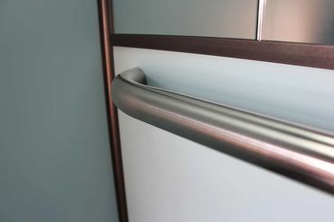 Detalle de un pasamanos de acero inoxidable en un elevador de pasajeros.