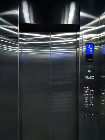 Vista frontal del interior de un elevador para pasajeros de acero inoxidable marca GIE Mexico