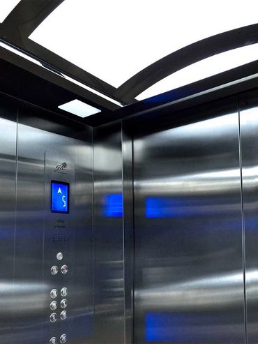 Vista de una de las paredes del interior y de sus puertas de un elevador para pasajeros