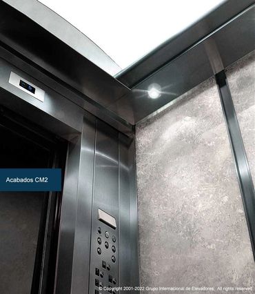 Vista a contrapicada de un elevador para pasajeros ASME A17.1 CSA B44 de mármol y acero inoxidable