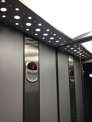 Interior de un elevador para pasajeros en acabado melanina color gris