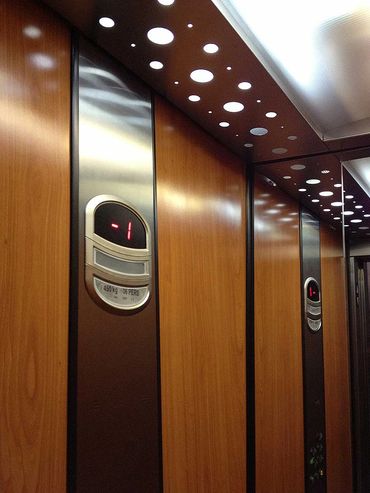 Interior de un elevador de pasajeros en con acabados de melanina tipo madera