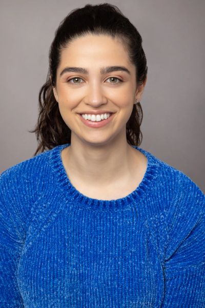 Young woman smiling in a blue sweater.