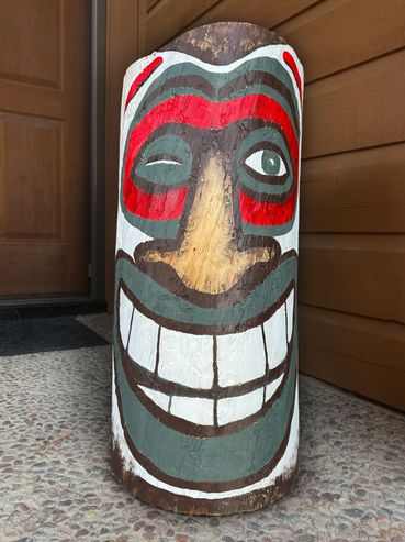 Wood log painted with a winking tiki face.